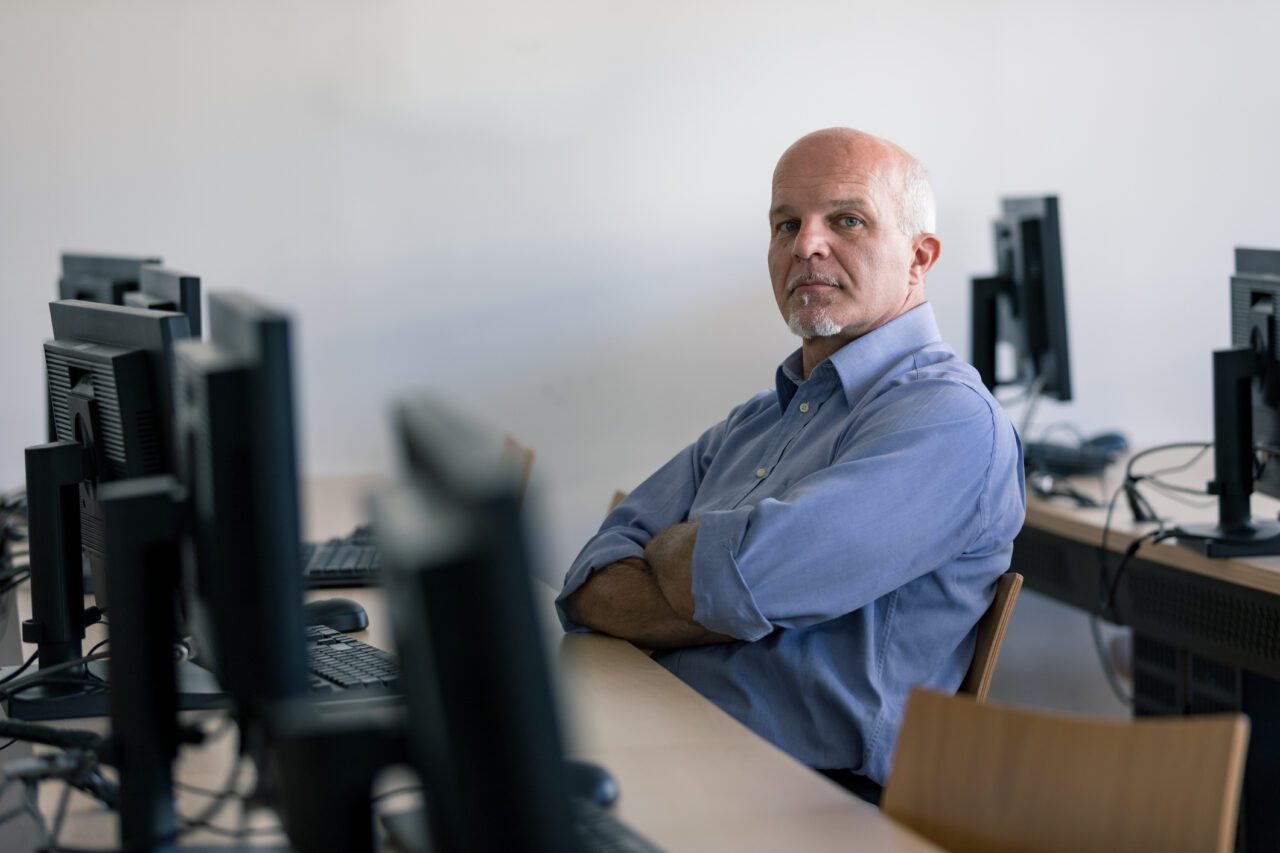 man-sitting-at-desk-crossed-arms