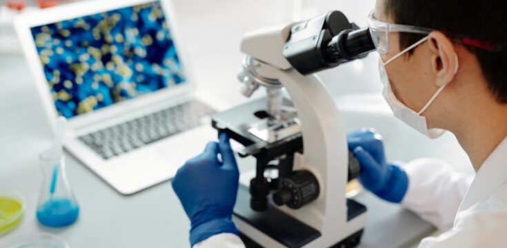 man-looking-into-microscope