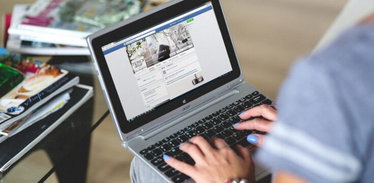 Laptop user engaging with social media at home