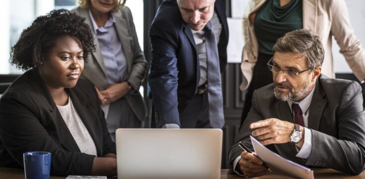 business-people-gathered-around-computer